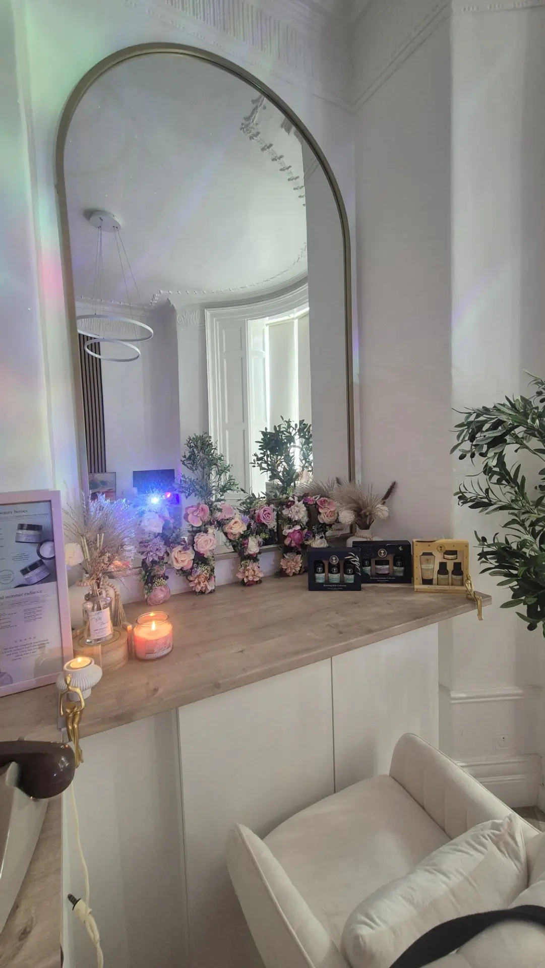 The GC Therapies reception area with an arched mirror, candles and flowers